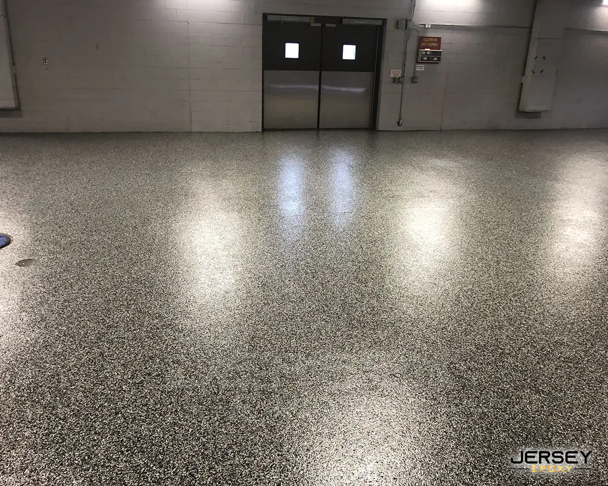 Durable epoxy flooring in industrial setting with glossy finish and speckled texture.