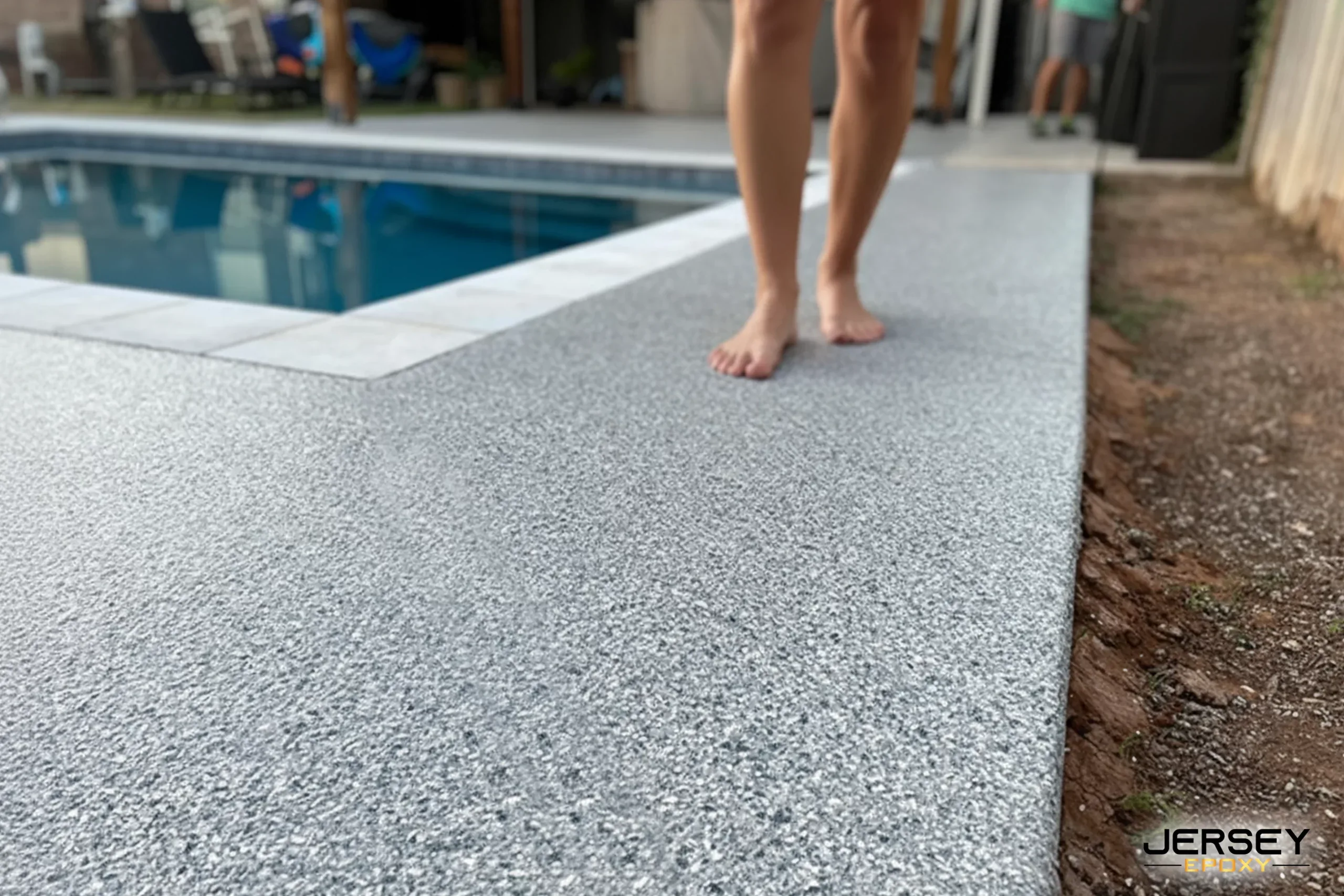 Seamless concrete pool deck with durable Jersey Epoxy coating for slip resistance.