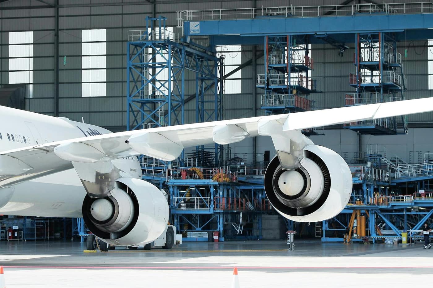 Aircraft under maintenance in a hangar bay where hydraulic fluid and fuel reach the floor