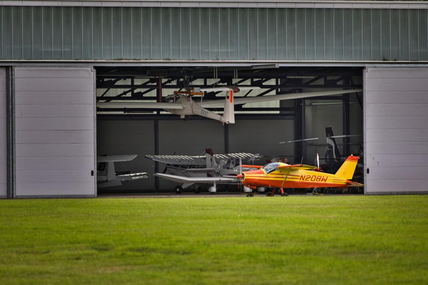 Bright reflective hangar floor under parked private aircraft