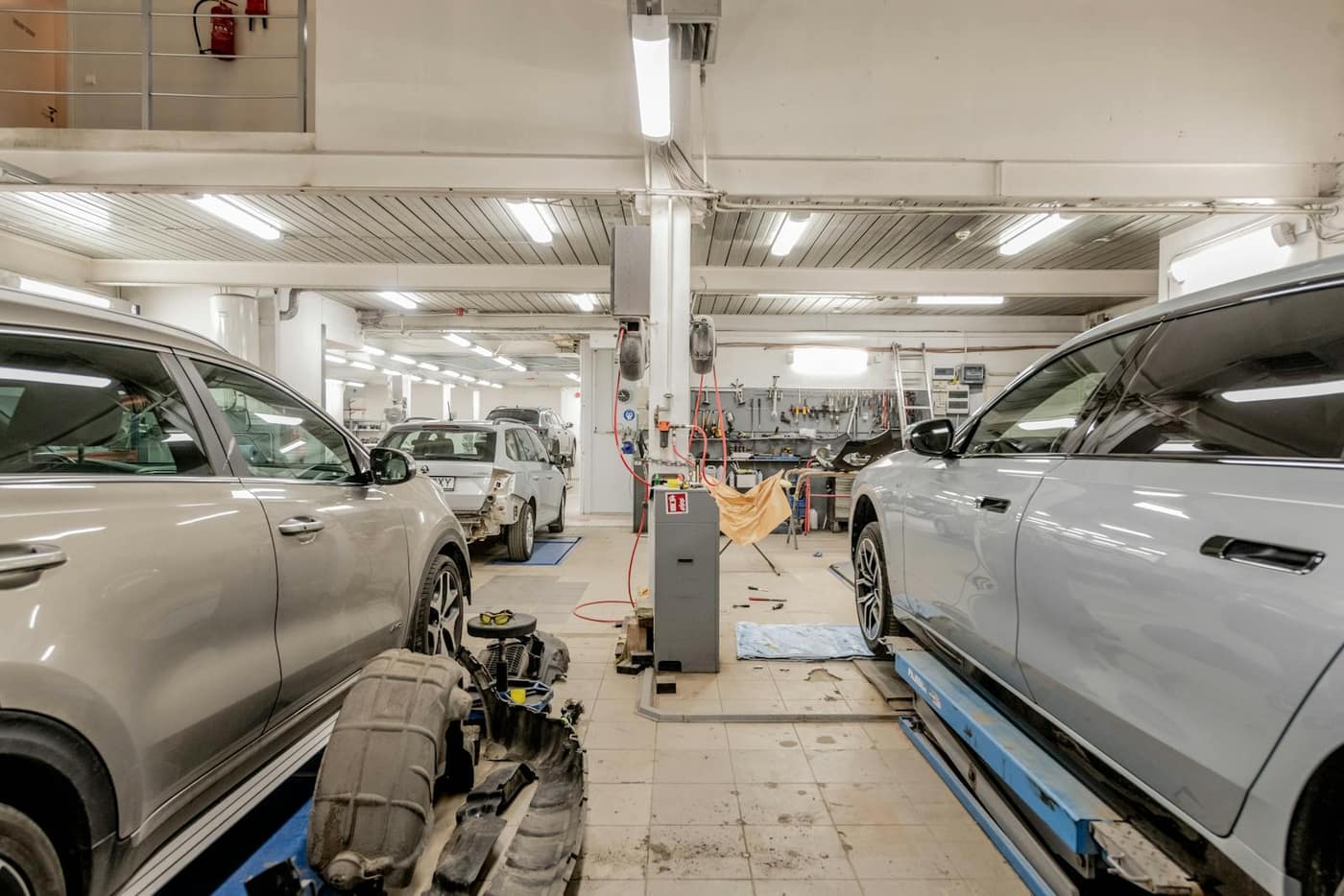 Interior of a busy auto service department with vehicles on lifts