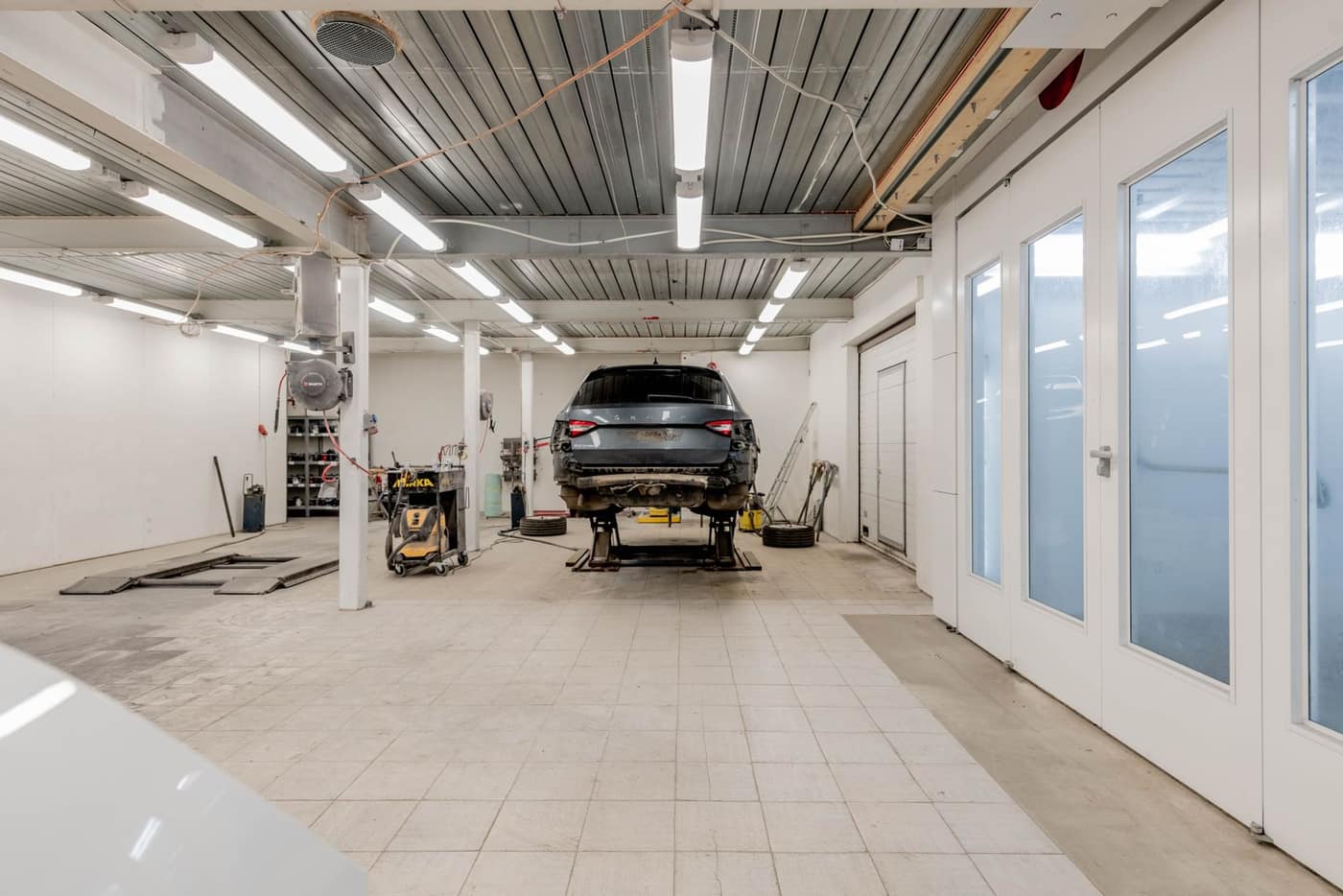 Service bay with a vehicle on a lift over a coated floor