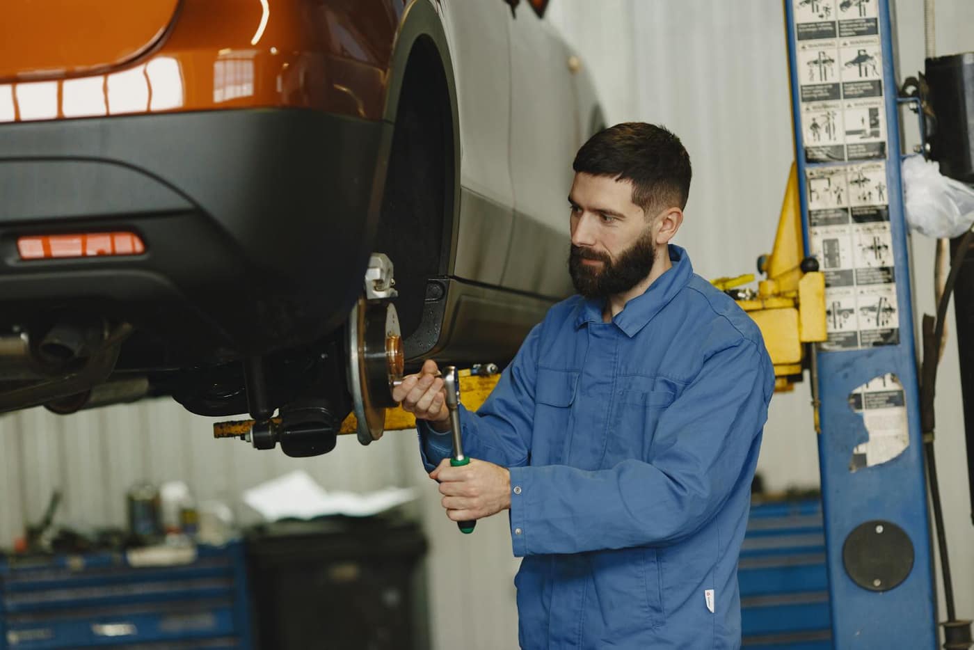 Mechanic working on the underside of a car in a shop