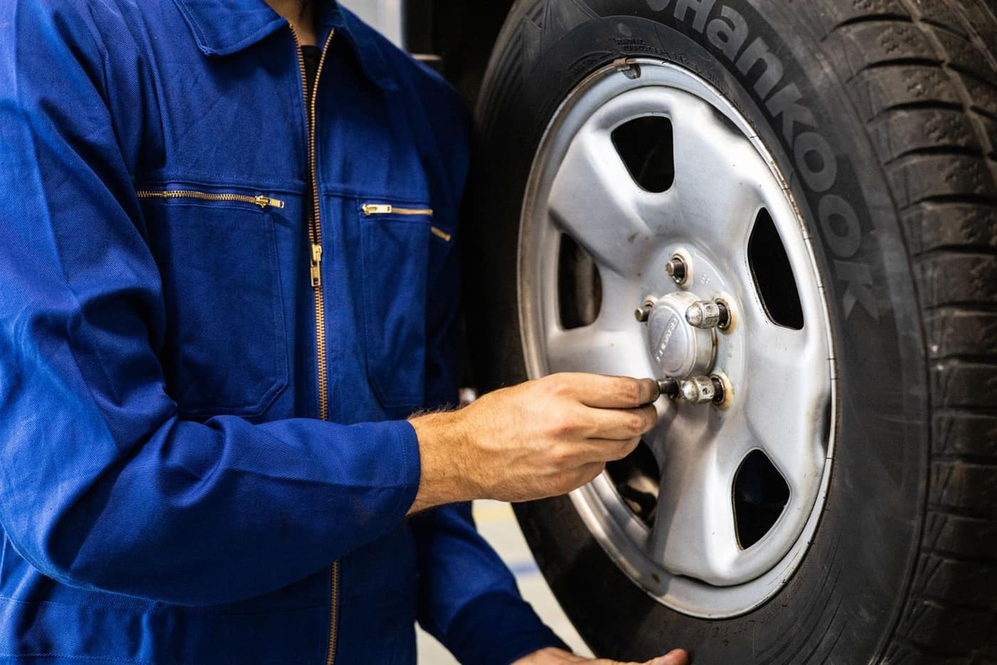 Technician handling a vehicle tire in a repair shop