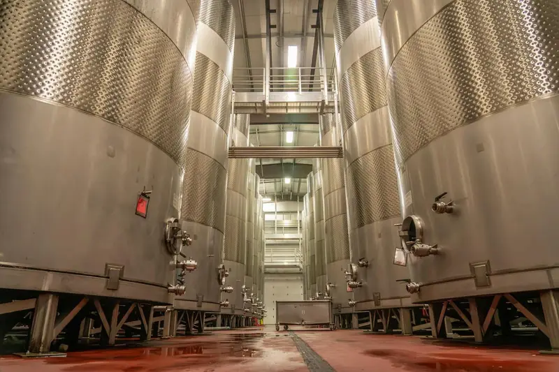 Stainless fermentation tanks in a working brewery above a seamless production floor
