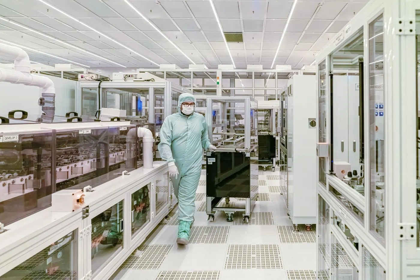 Gowned technician in a classified cleanroom standing on a seamless, low-particulate resinous floor