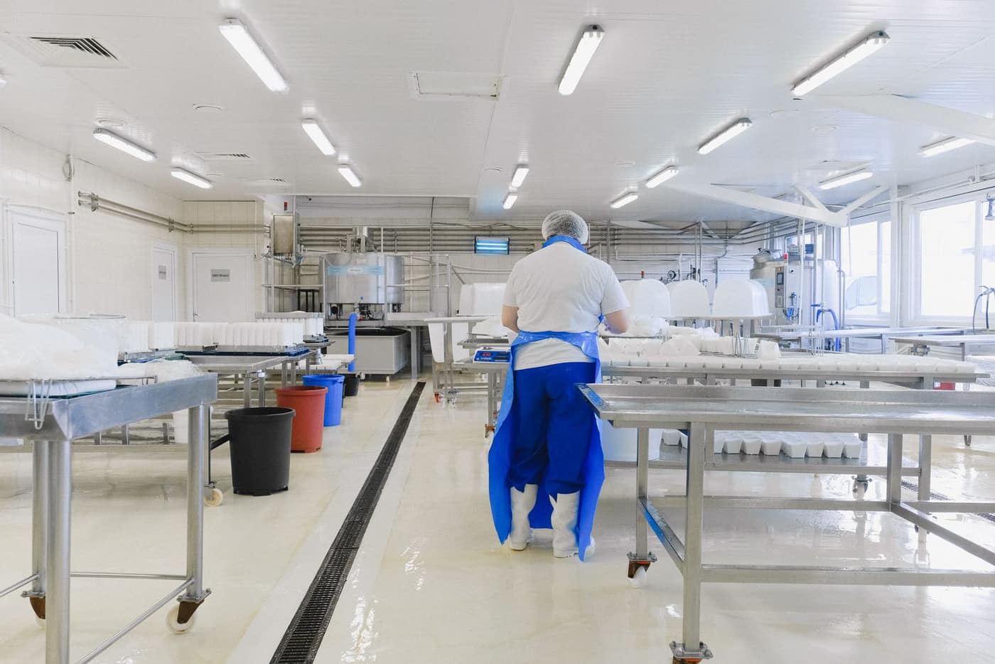 Gowned worker in a bright, controlled cleanroom environment