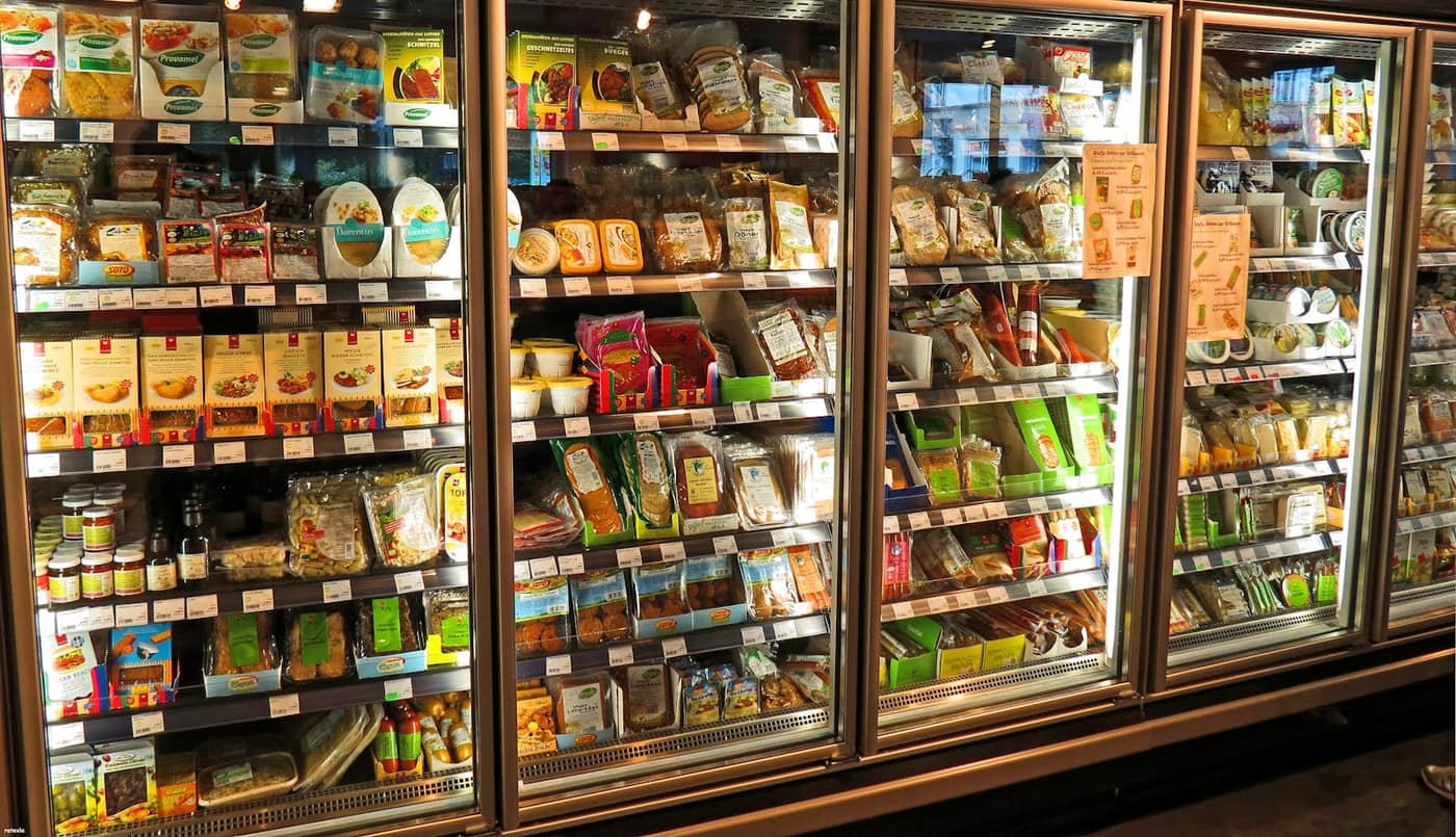 Frosty refrigerated cold storage aisle lined with stocked shelving