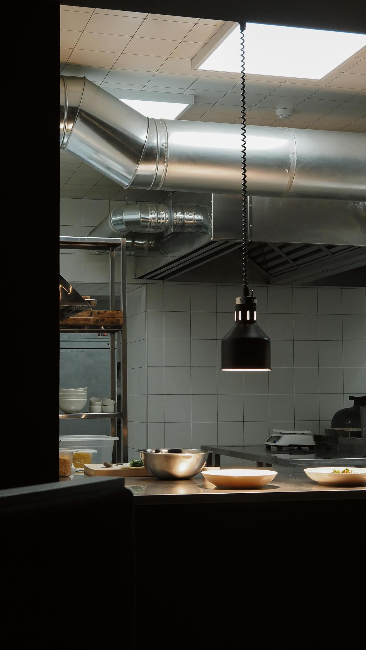 Seamless light-reflective floor running the length of an industrial kitchen