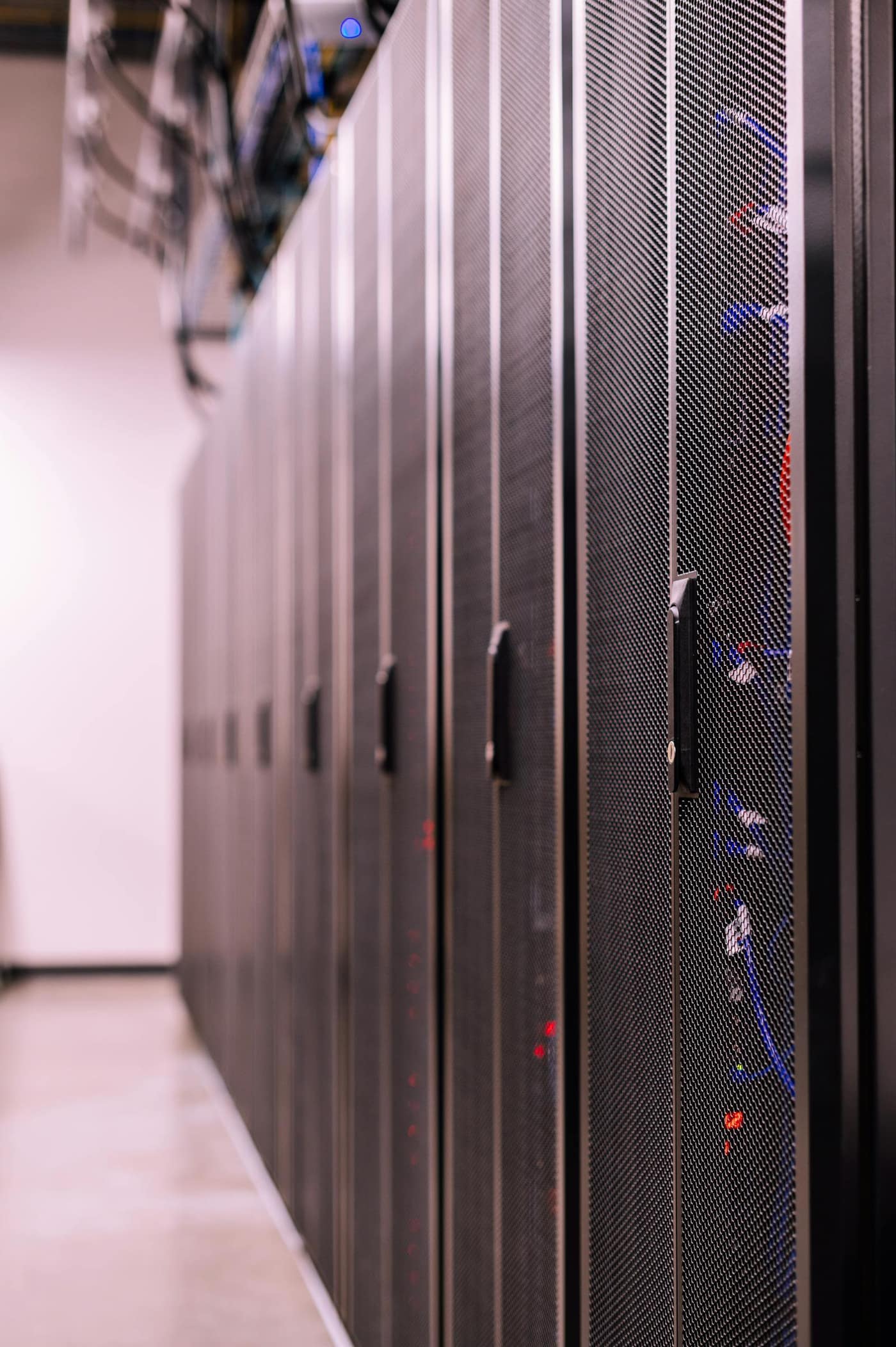 Long aisle of cabinets in a data hall with a sealed floor running between them