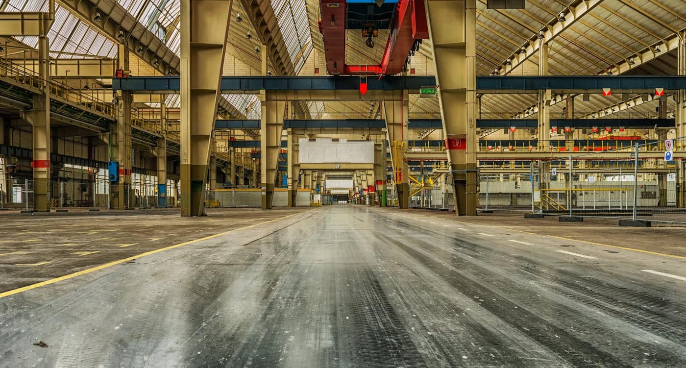Long, light-reflective sealed concrete floor in a large industrial building