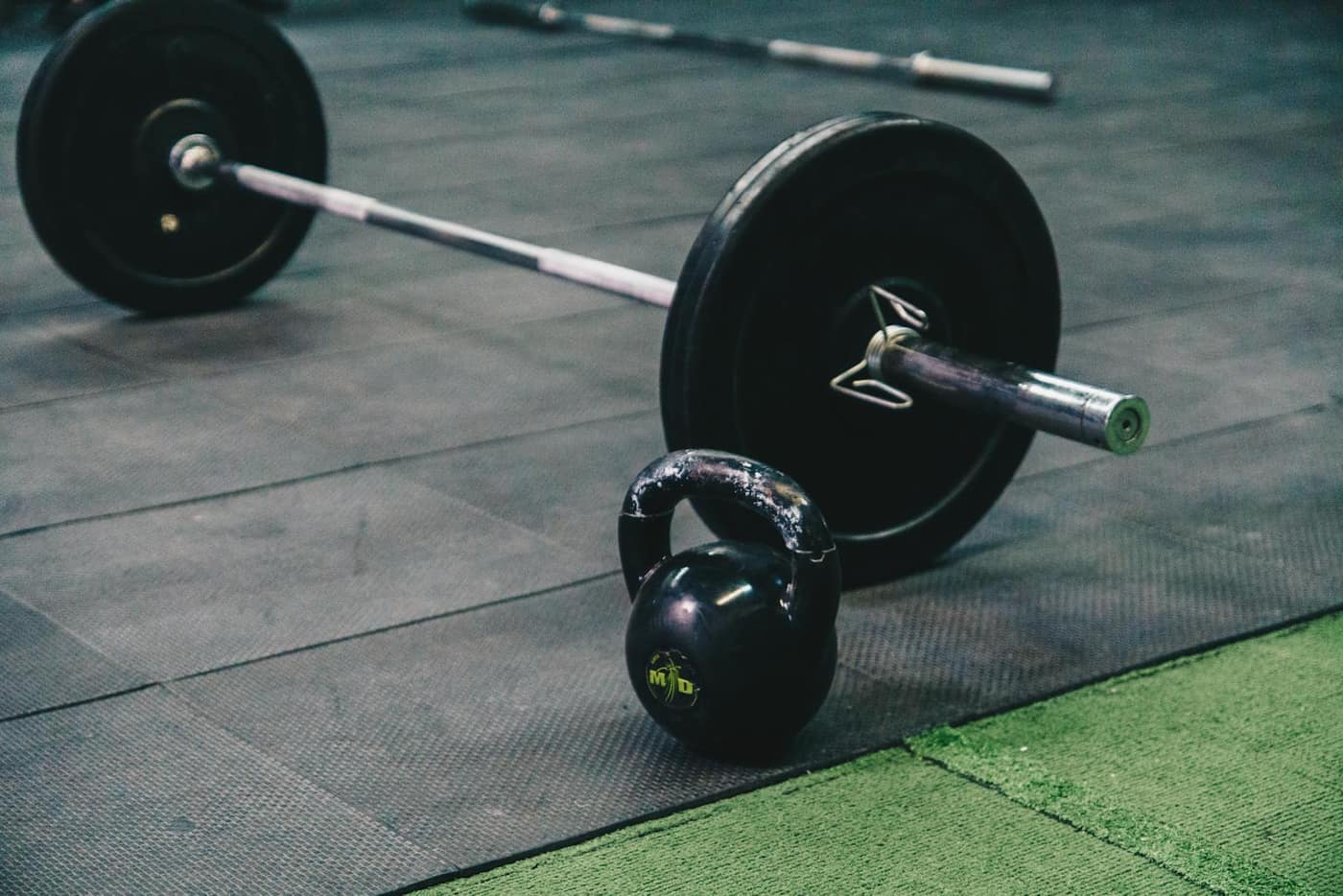 Barbell and kettlebell on a durable weight-room floor