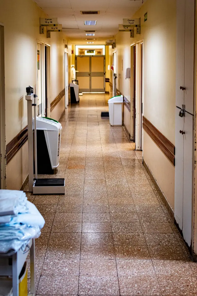 Bright hospital corridor with a continuous seamless floor running to the wall