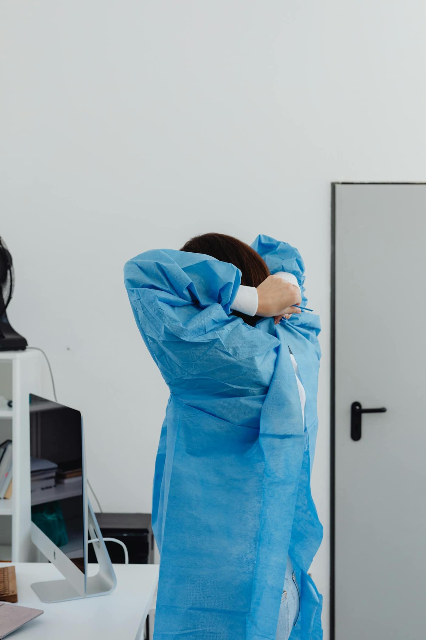 Technician in PPE in a clean lab corridor