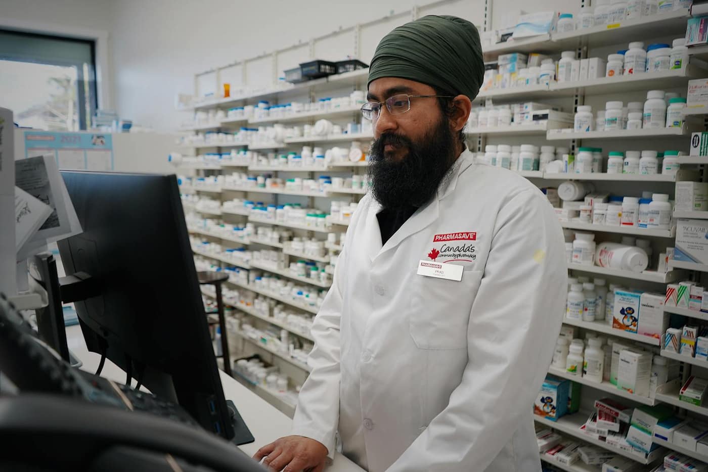 Pharmacist working at a counter in a clean, controlled pharmacy environment