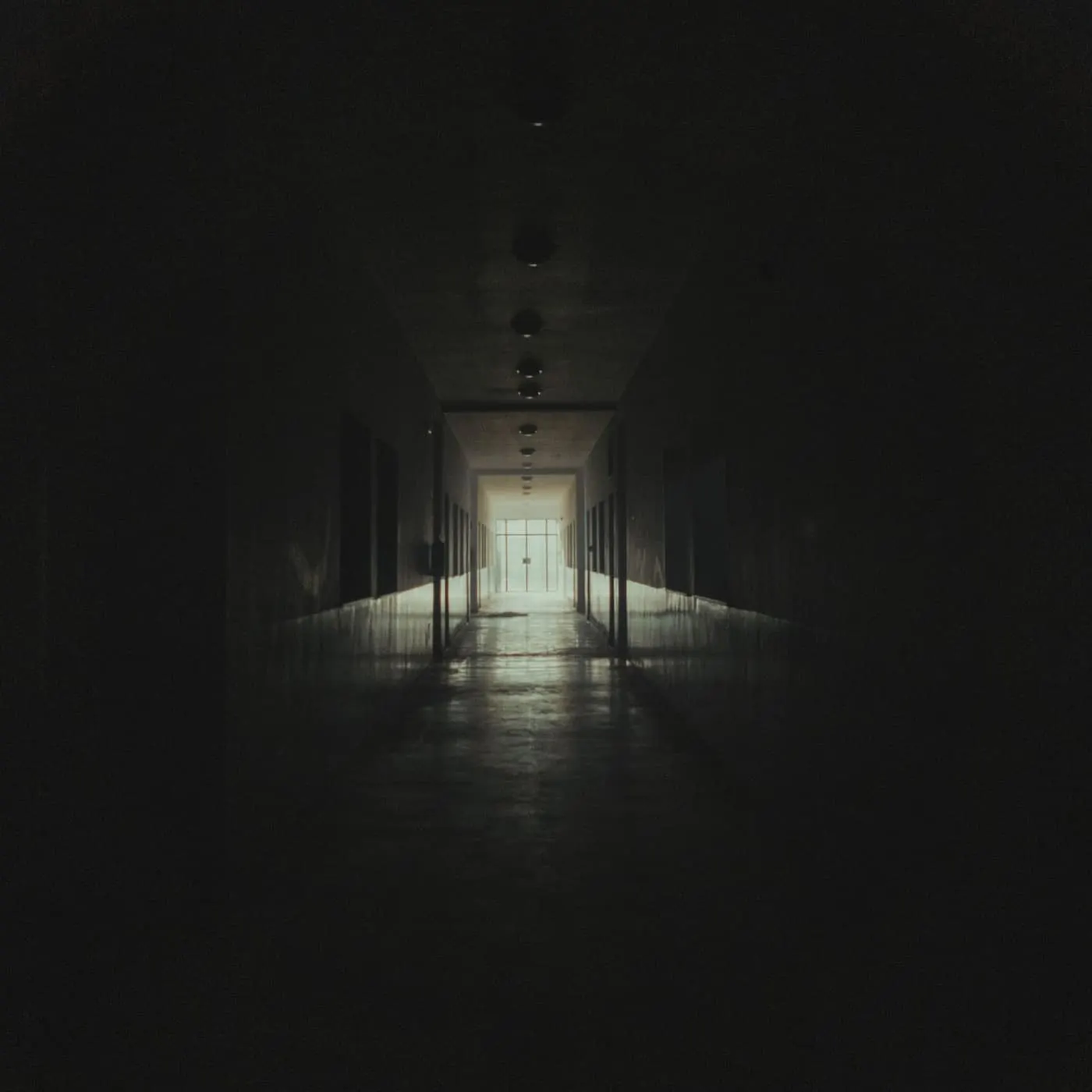 Long school corridor with a clean, seamless hard floor between rows of lockers
