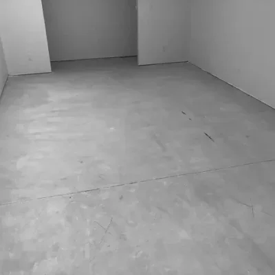 Smooth concrete floor in an unfinished room with gray epoxy coating.