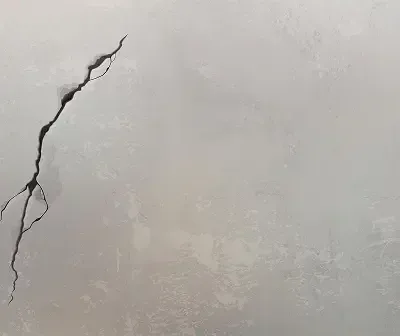 Cracked concrete floor with visible damage and surface imperfections.